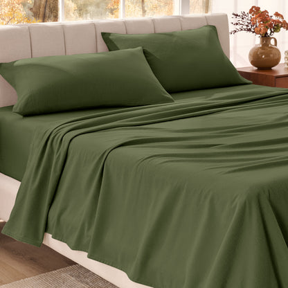 Bed sheets on a neatly made bed in a bright bedroom with large windows.