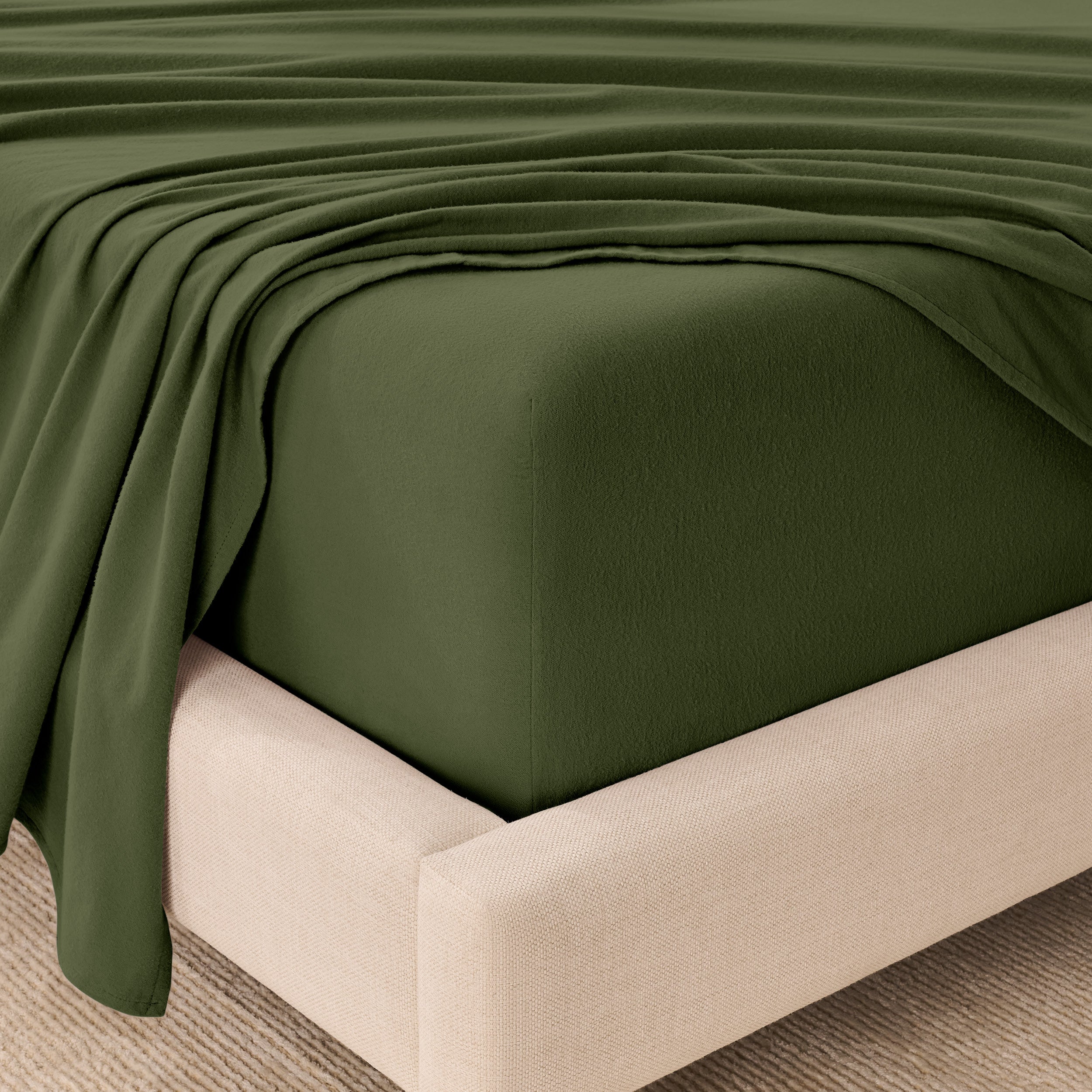 Fitted sheet and top sheet on a mattress with a beige bed frame