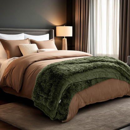 A shaggy faux fur blanket at the end of a bed