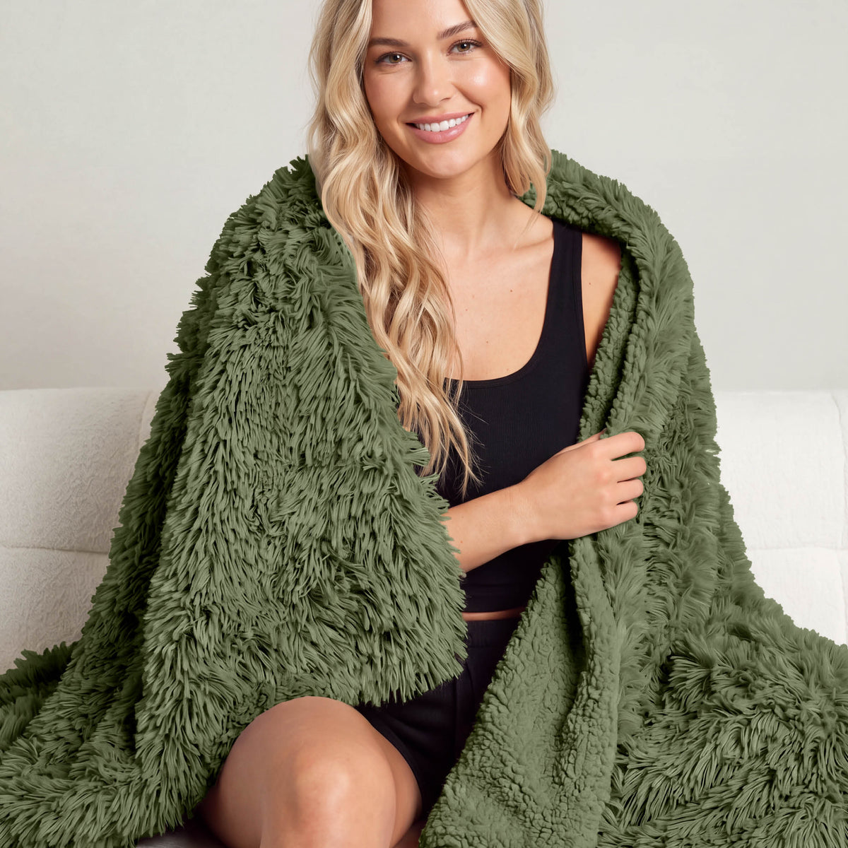 A woman sitting with a shaggy blanket wrapped around her
