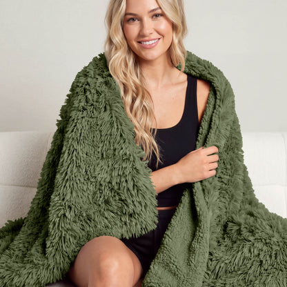 A woman sitting with a shaggy blanket wrapped around her