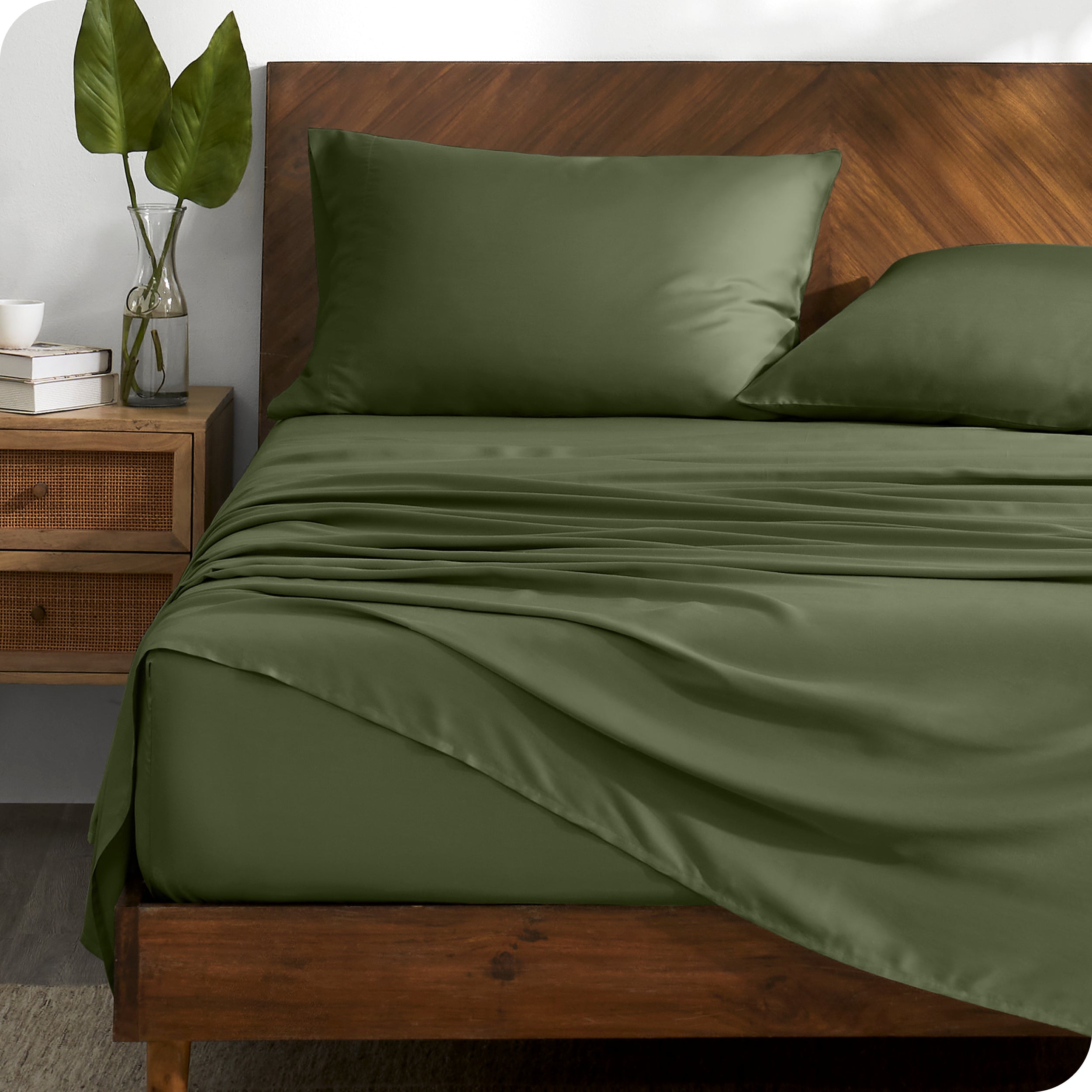 TENCEL™ sheet set on a bed with the flat sheet loosely draped over the top. The mattress is on a wooden bed frame.