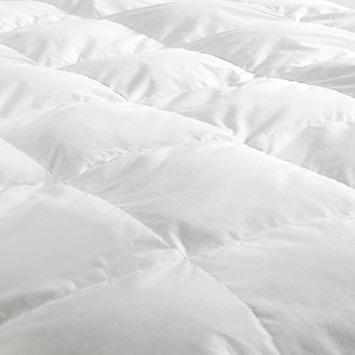 Close-up of a white down comforter with a soft texture.
