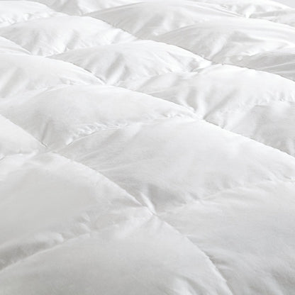 Close-up of a white down comforter with a soft texture.