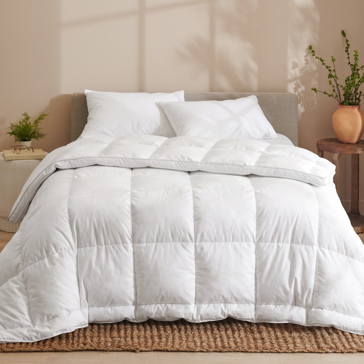White down comforter on a bed with pillows in a bedroom setting