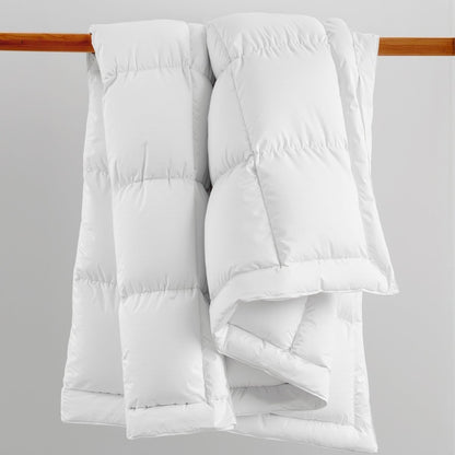 White down comforter on a wooden rod against a gray background