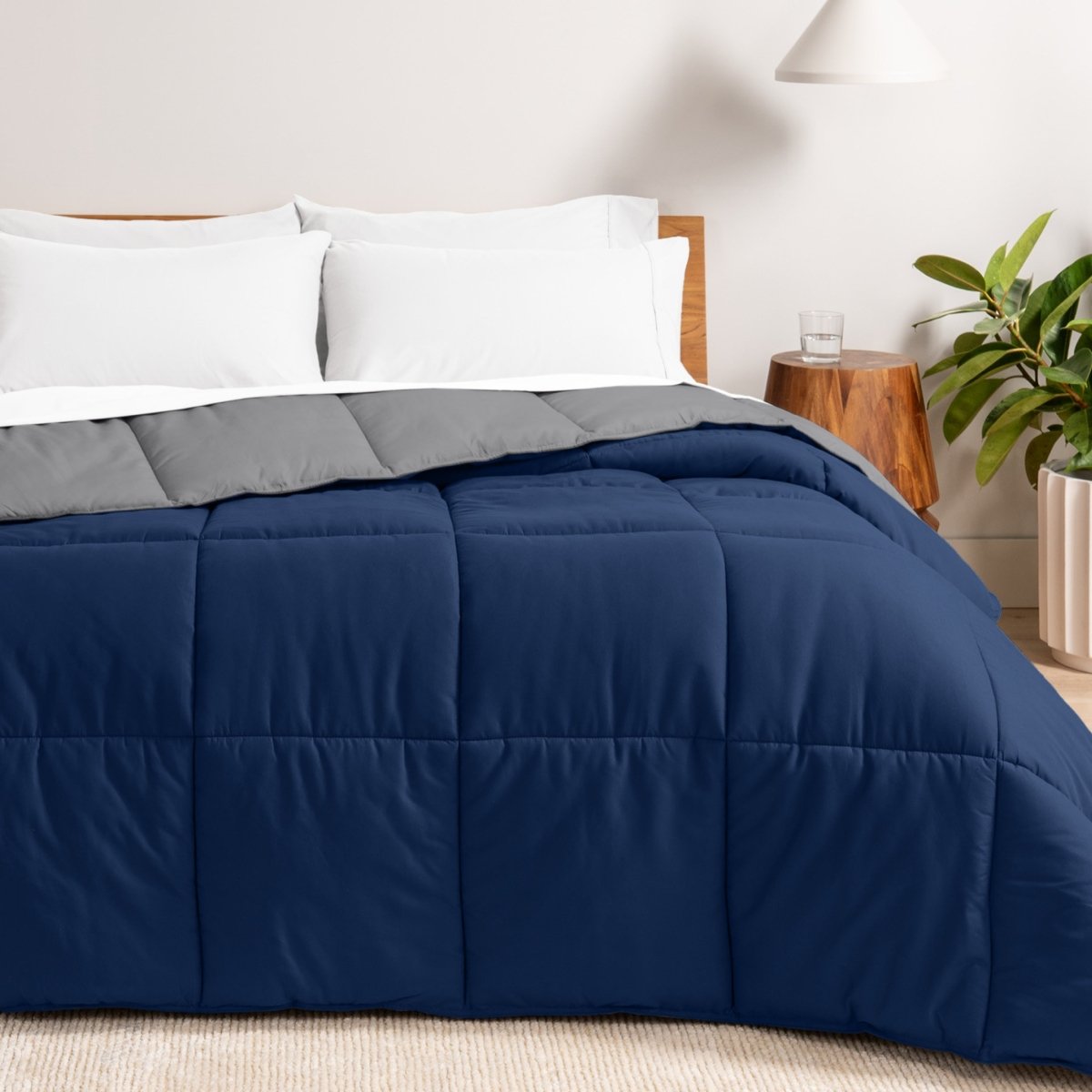 Bed with reversible comforter and white pillows in a bedroom setting