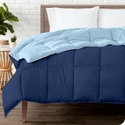 Wooden bed frame with a reversible comforter on the mattress. The comforter is folded back showing the two different colored sides.