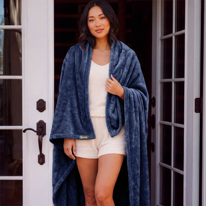 A woman standing with a microplush blanket wrapped around her