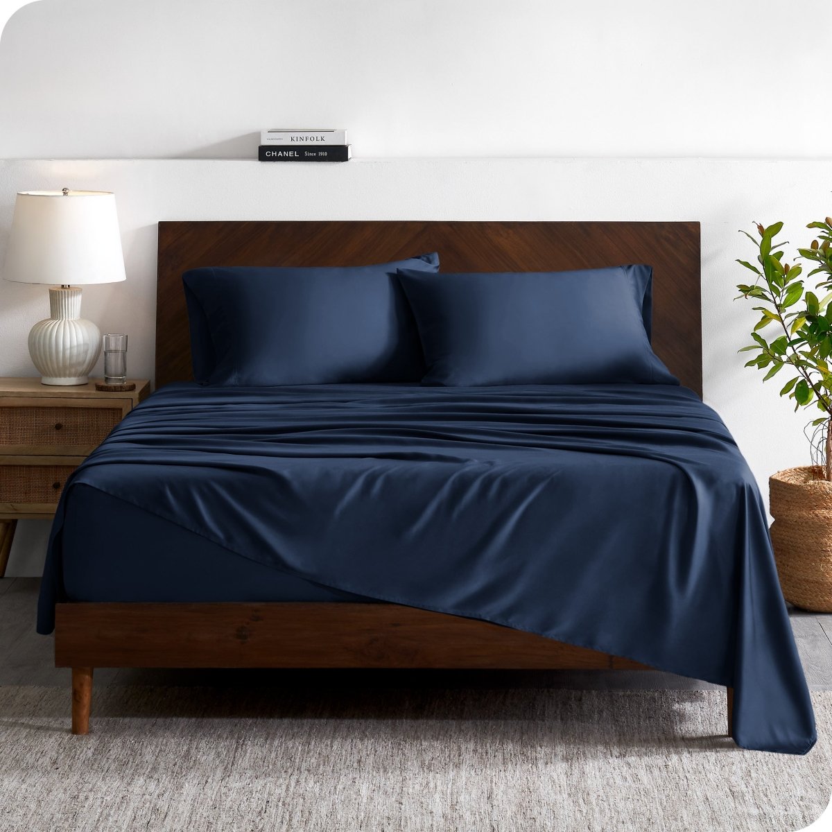 A contemporary bed with a sheet set and a wooden headboard.