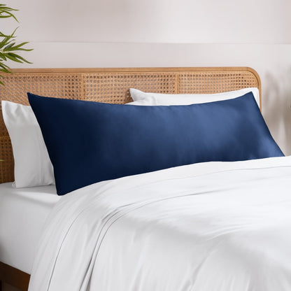 Body pillowcase on a pillow set on a bed with a wicker headboard and a plant in the corner.