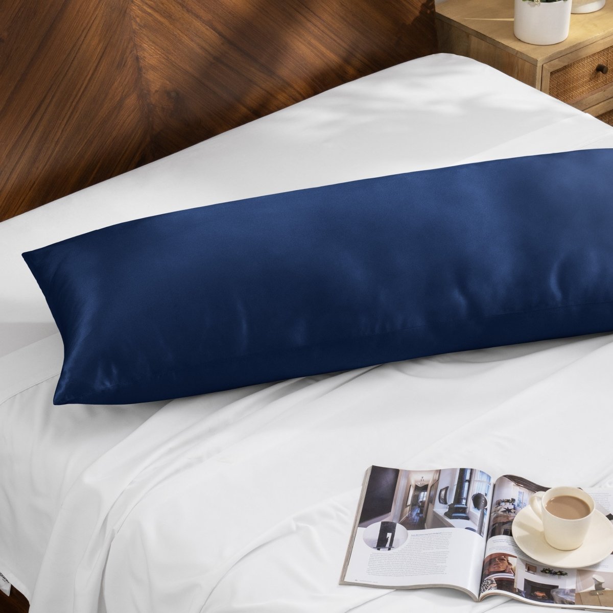 Bamboo pillow on a bed with a magazine and cup of coffee on a wooden nightstand.