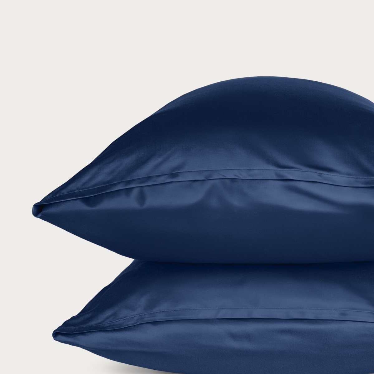 Bamboo pillowcase and bedding against a woven headboard with a plant in the corner.