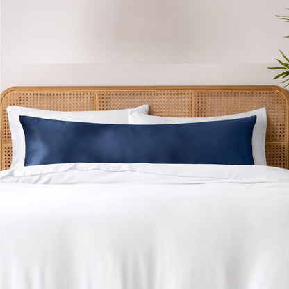Pillows, sheets and a duvet cover on a bed with a wicker headboard and light gray bedding.