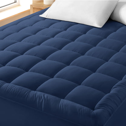 A cotton top mattress pad on a mattress in a modern bedroom.