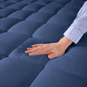 Close up of a cotton mattress pad showing the box-stitching.
