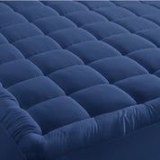 A mattress pad on a bed with 2 pillows on top