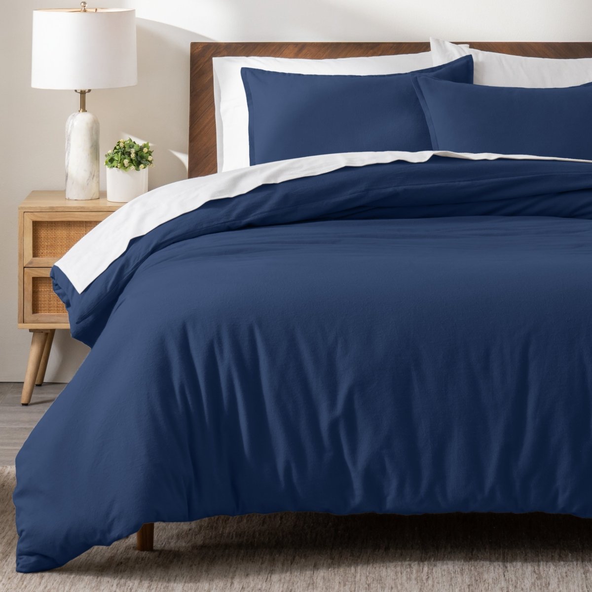 Flannel bedding set on a bed in a bedroom with a nightstand and lamp.