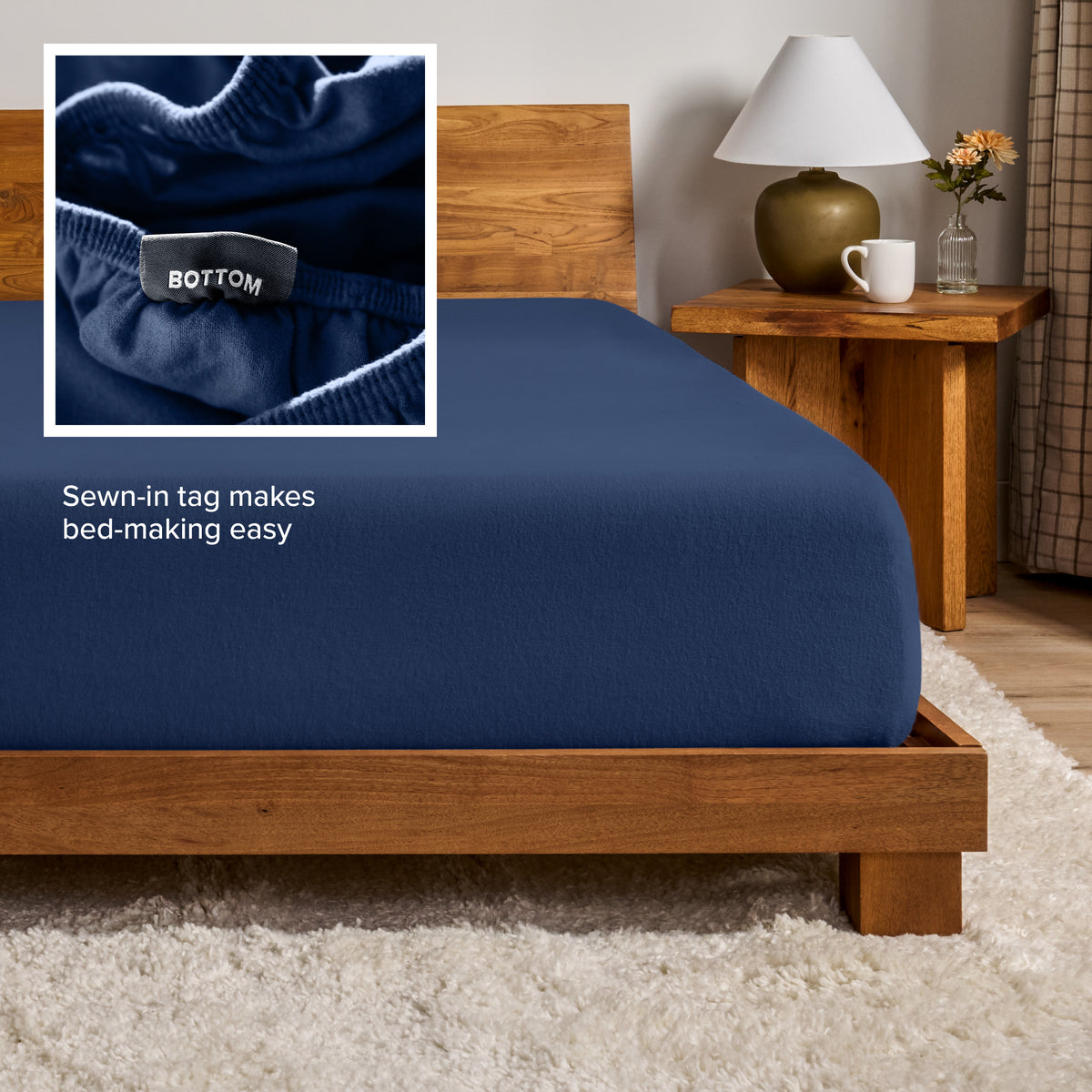 A flannel fitted sheet on a mattress with a wooden bed frame