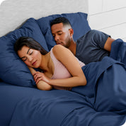 A couple sleeping with their heads resting on pillows with flannel pillowcases on them