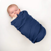 A baby swaddled in a receiving blanket