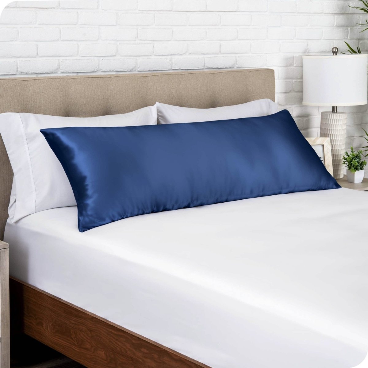 A silk body pillowcase on a pillow resting on a headboard