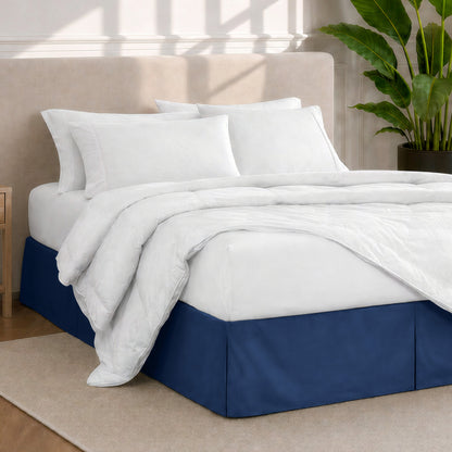 A modern bedroom with a bed skirt, comforter and sheets on the bed