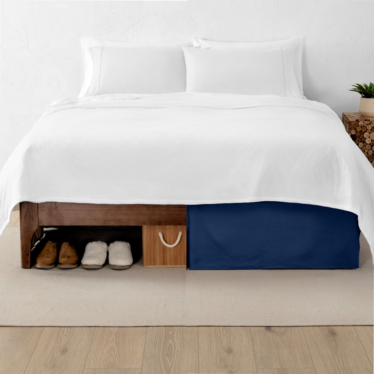 One side of a bed has shoes and a box under it while the other side has a bed skirt so that under the bed is hidden from view