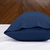 Body pillowcase with an envelope closure on a bed with a wooden headboard