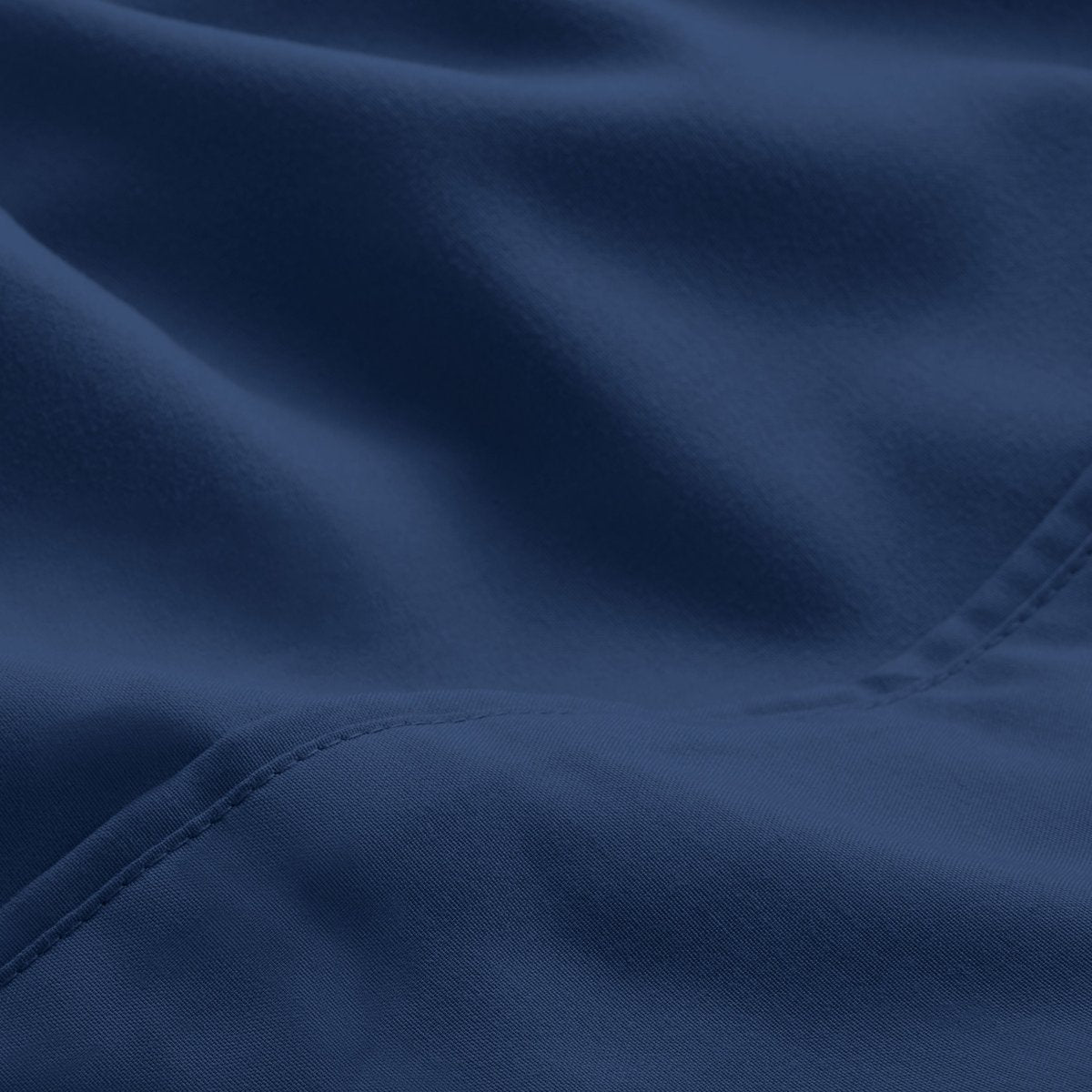 A close-up of microfiber fabric with soft folds and a visible stitched seam.