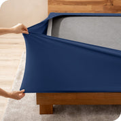 A person stretching a box spring cover