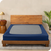 A cover on a box spring set on a wooden bed frame