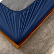 The corner of a box spring with a cover on it