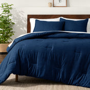 Bedding set on a bed in a bedroom with a side table and lamp.