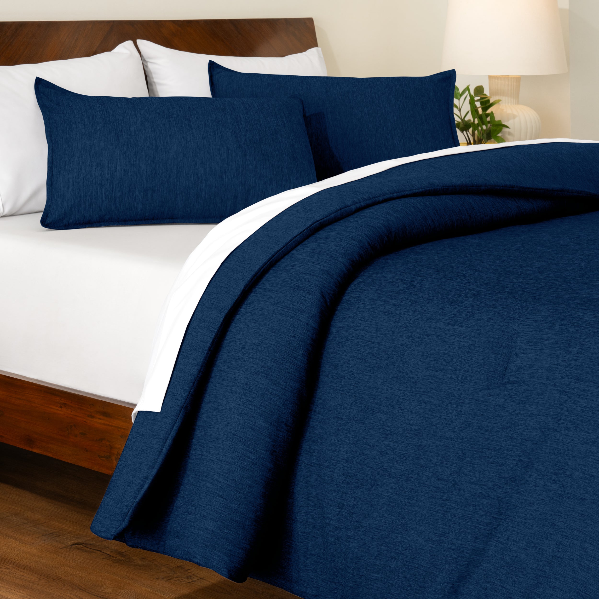 Track stitch comforter on a bed with white pillows and a wooden headboard.