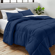 Comforter on a bed with white pillows and a plant in the corner.