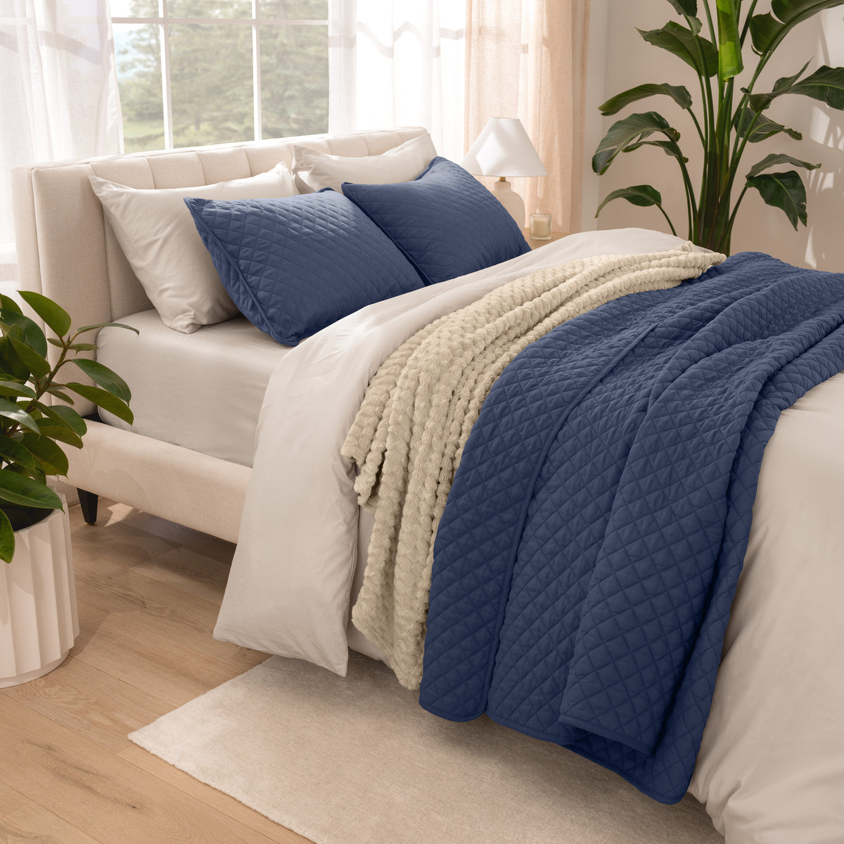 Side view of bed with coverlet set draped on a bed made with a duvet set