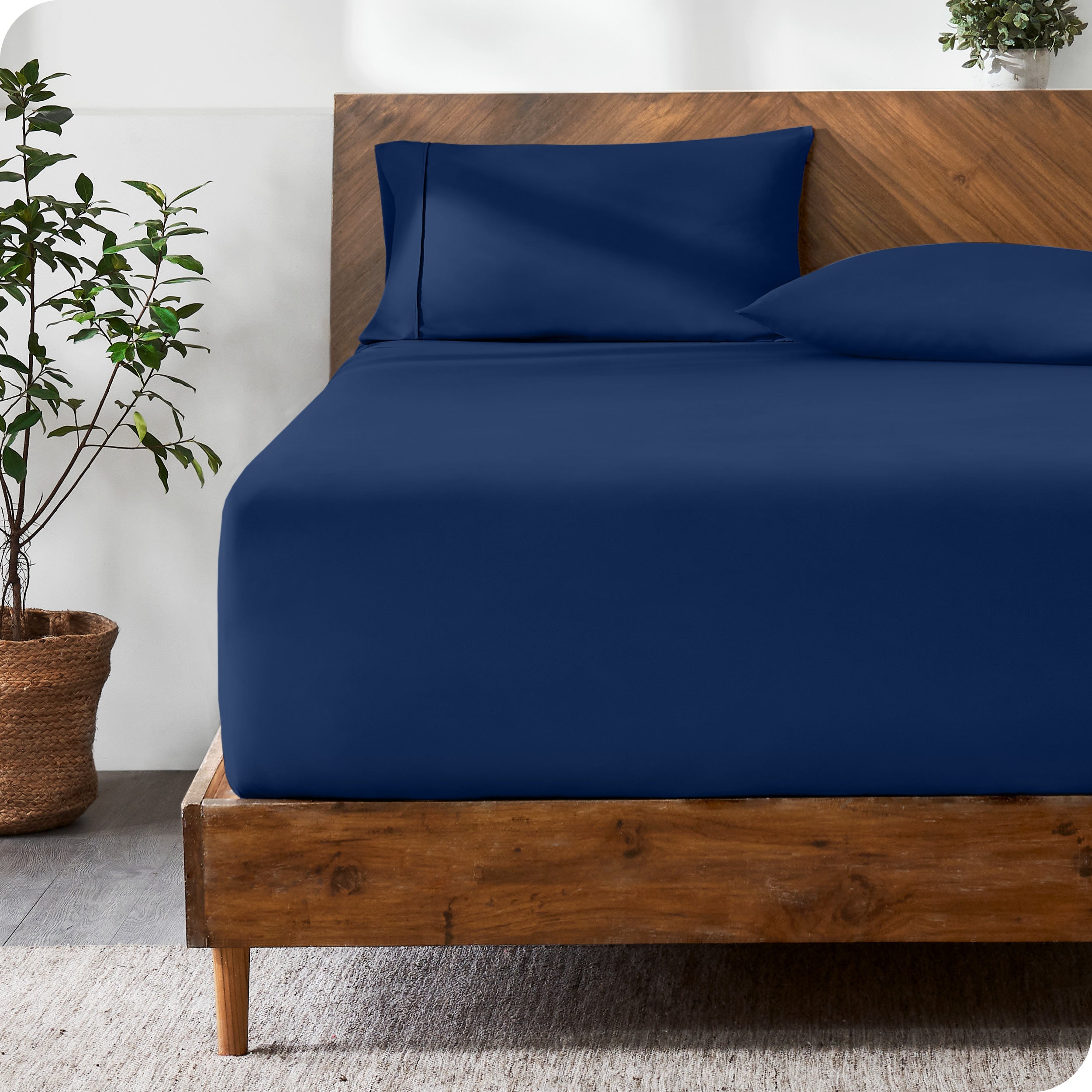 Wooden bed with ultra soft bedding in a minimalistic room.