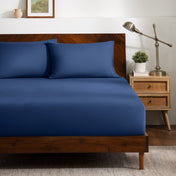 A bed dressed in a fitted sheet and two matching pillowcases.