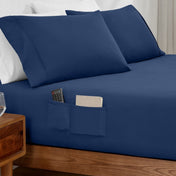 Remote control and journal in the pockets of a fitted sheet