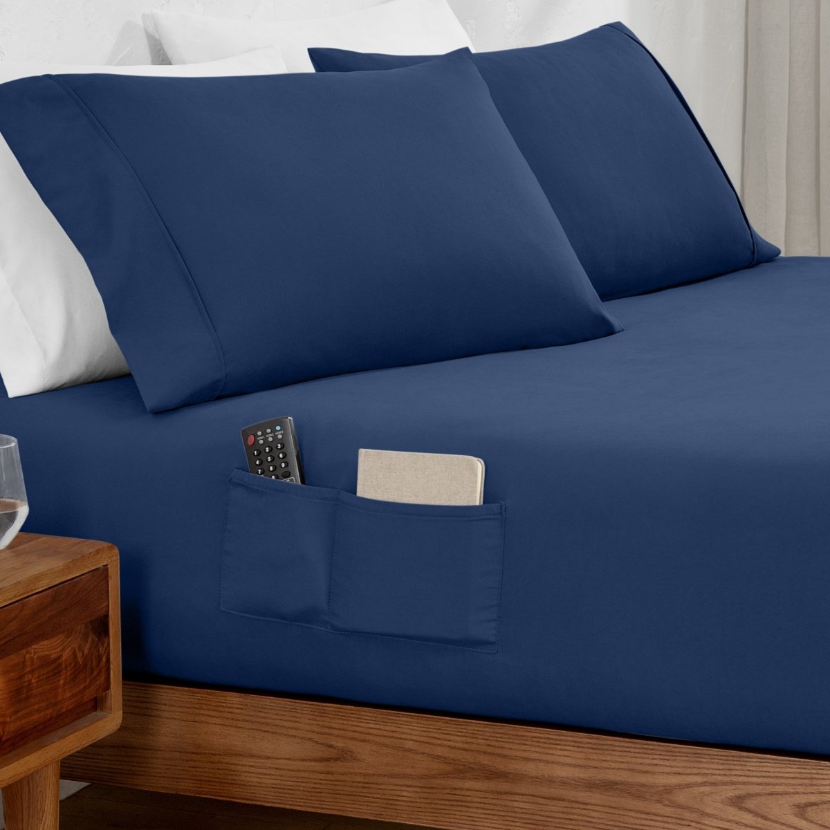 Remote control and journal in the pockets of a fitted sheet