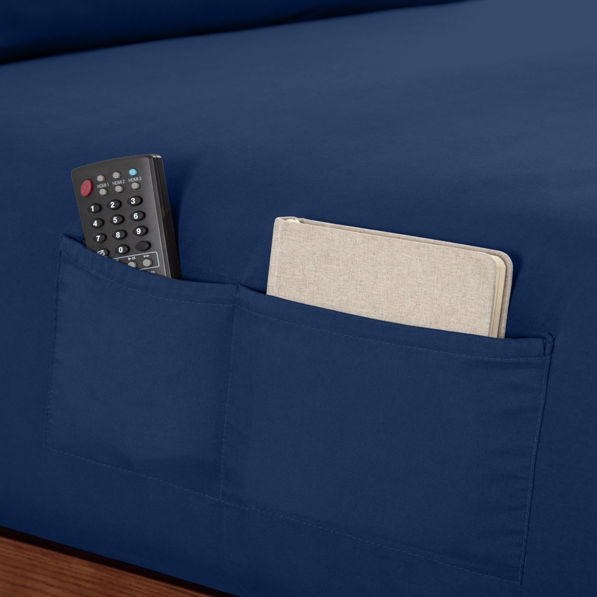 Remote control and journal in the pockets of a fitted sheet