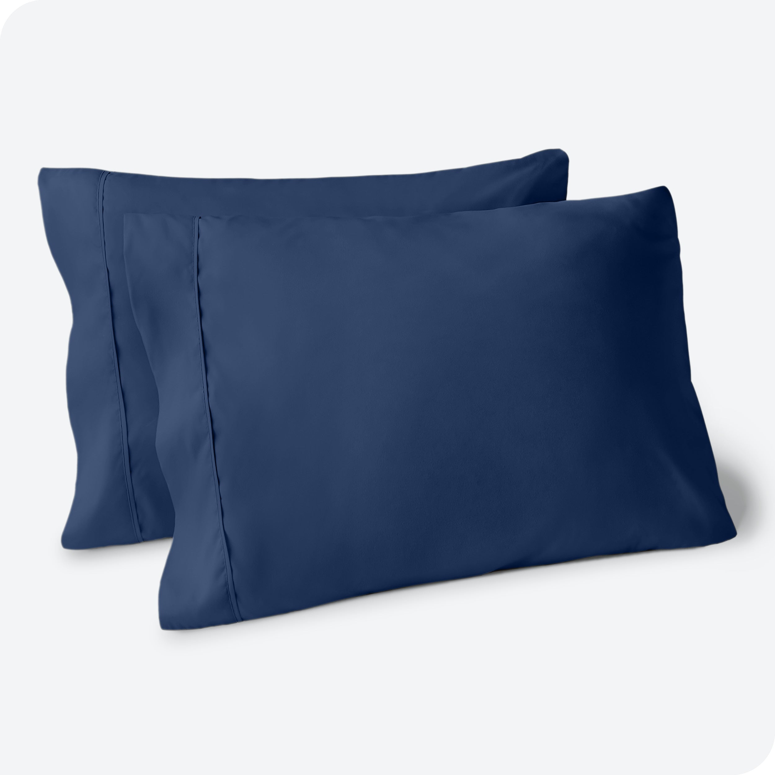 Two pillows on a white background with blue pillowcases on them