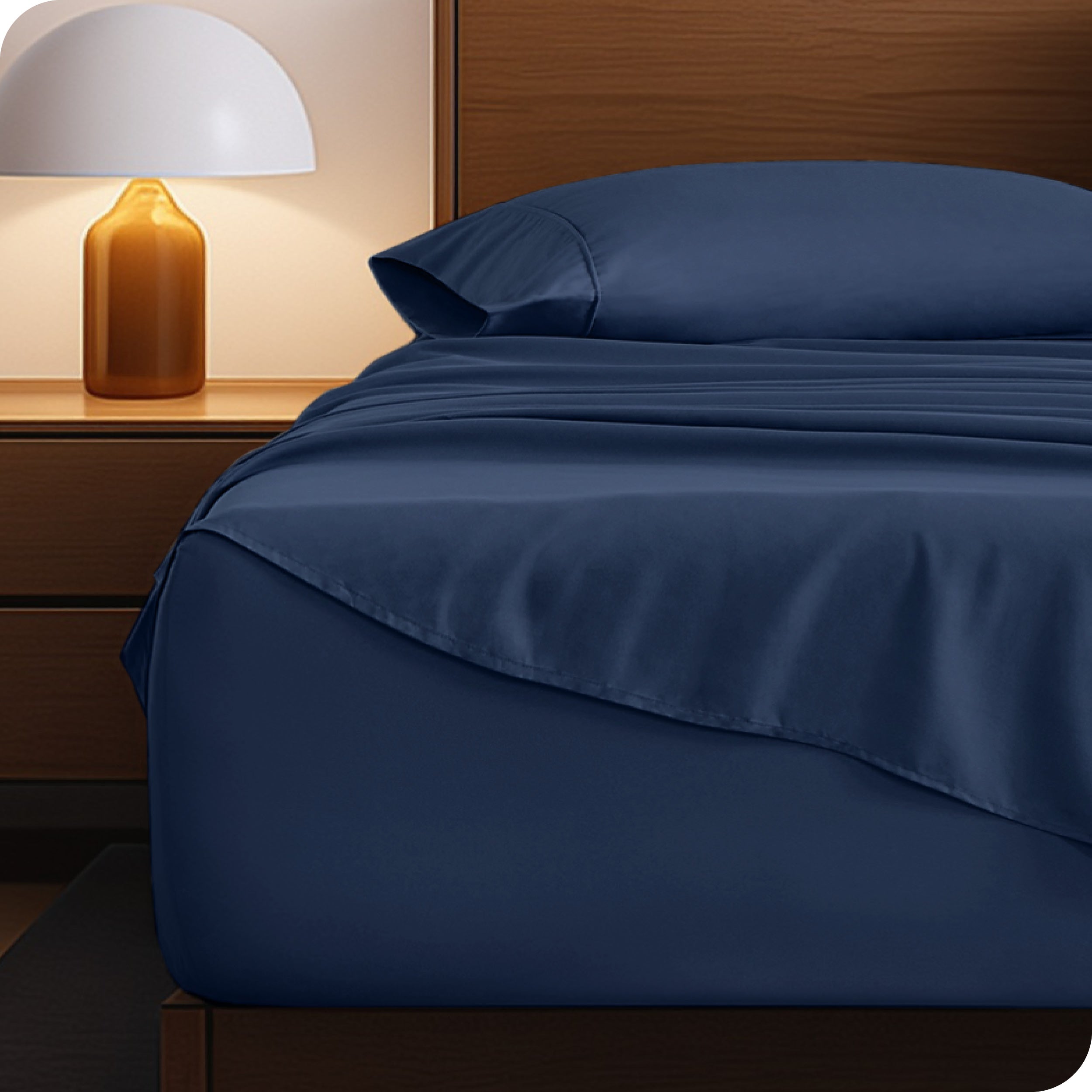 Microfiber bed sheets on a neatly made bed with a wooden headboard and nightstand.