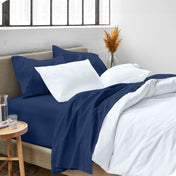 A modern bed made with a microfiber sheet set and duvet set. The duvet set and sheet set are folded over part way down the bed.