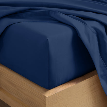 Close up of the corner of a mattress with a fitted sheet and flat sheet on it