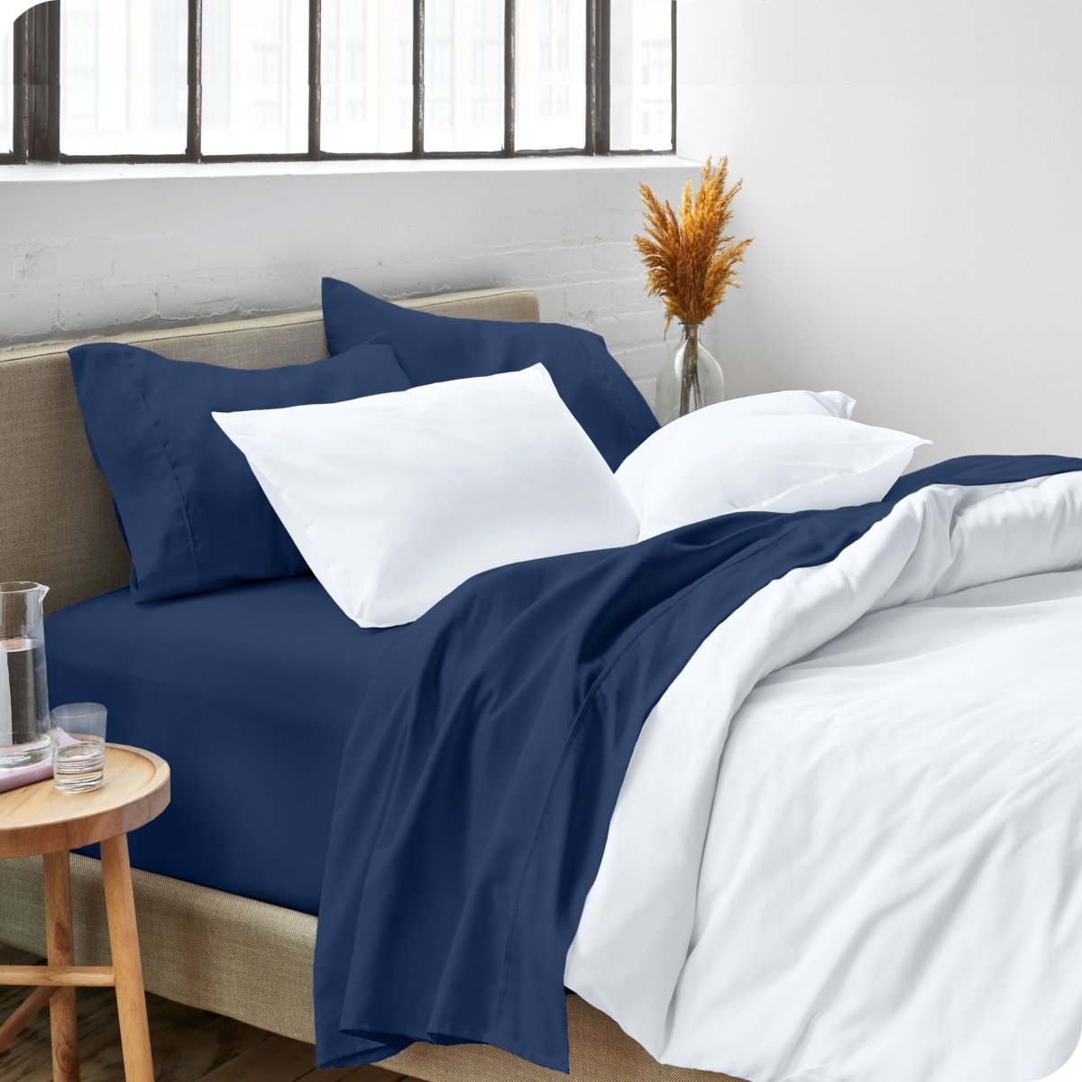 A side view of a bed made with microfiber sheets and a white duvet cover