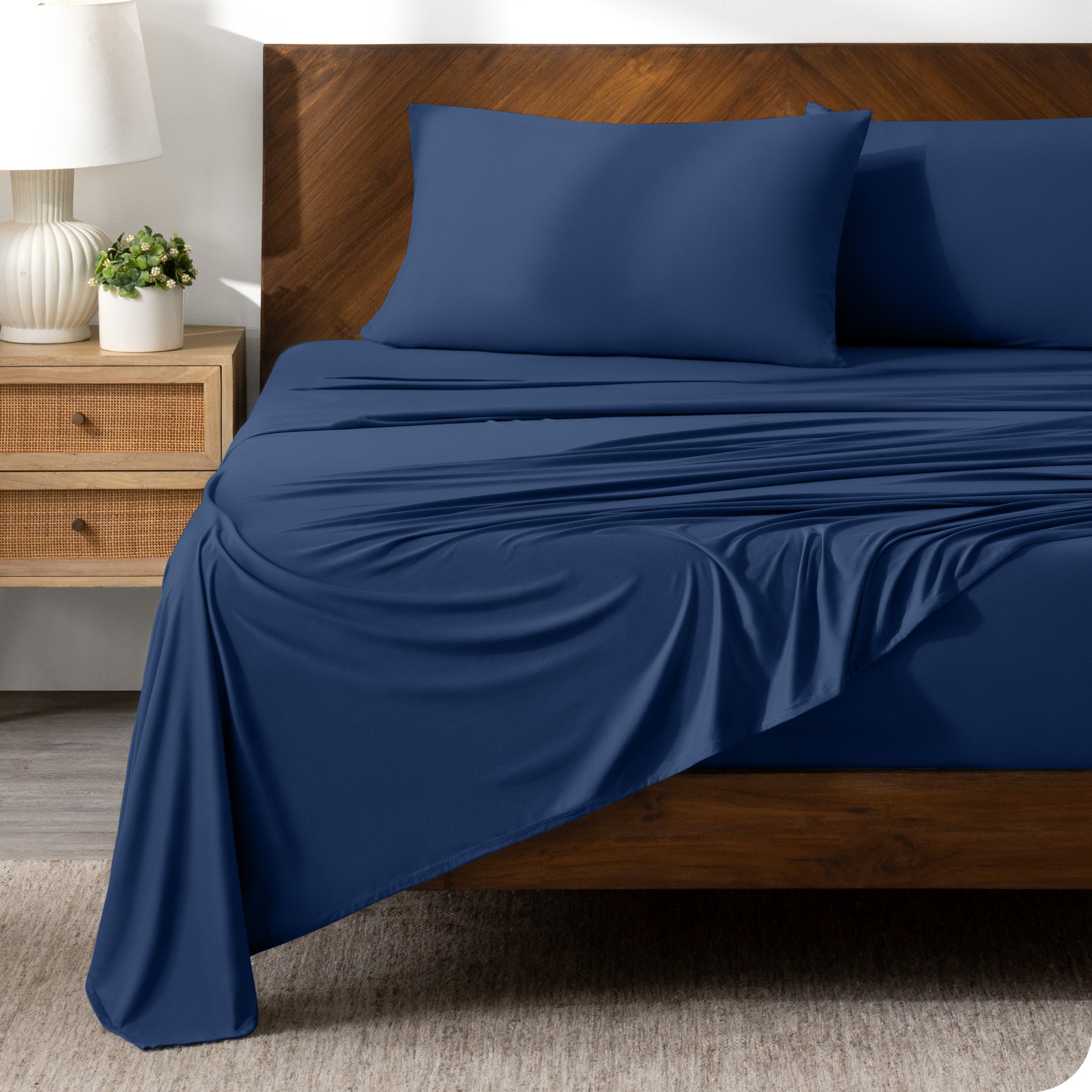 Dark Blue sheet set on a bed with a dark wooden bed frame