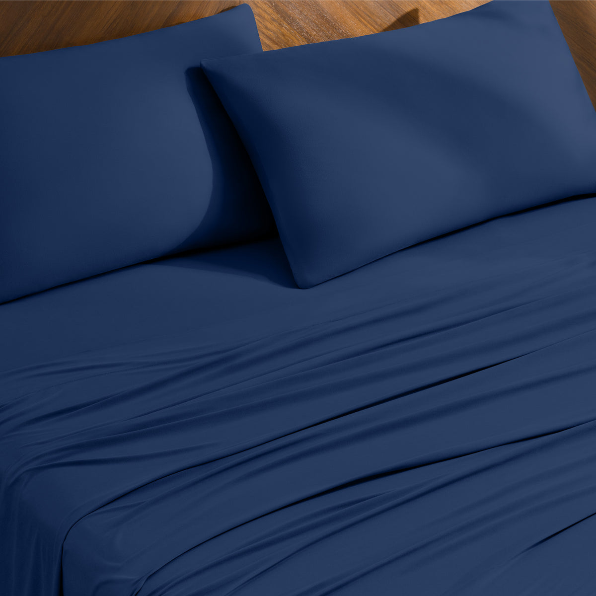 Bed sheets and pillowcases on a bed with a wooden headboard