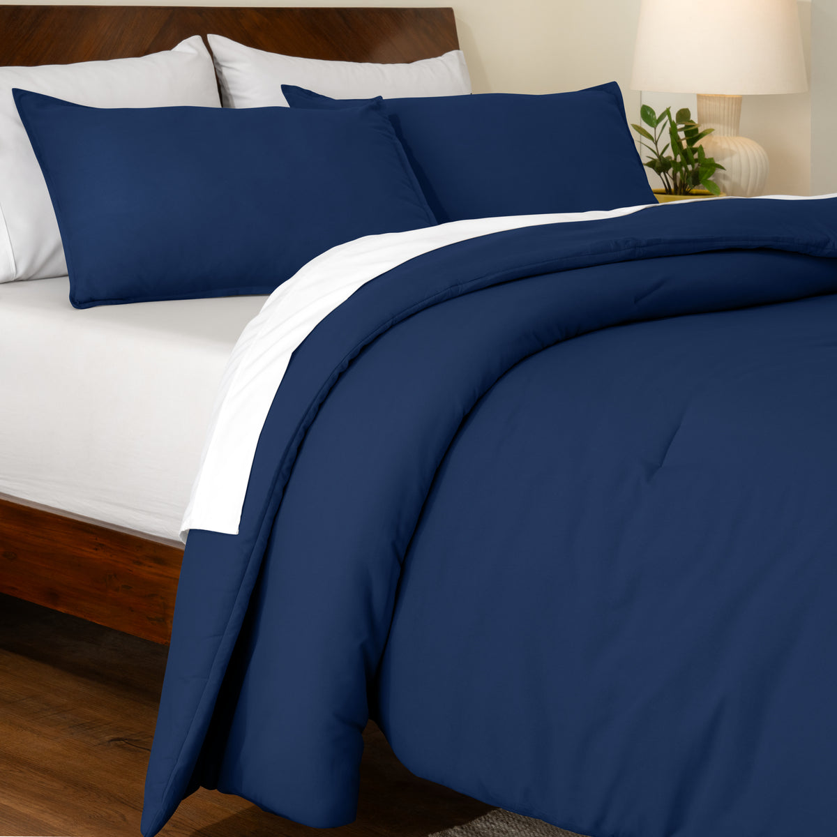 Track stitch comforter on a bed with white pillows and a wooden headboard.